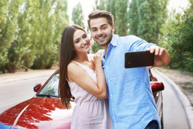 Güzel genç çift alarak selfie car yakınındaki