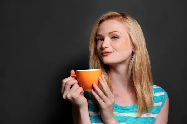 Hermosa chica con taza de café sobre fondo gris — Foto de Stock