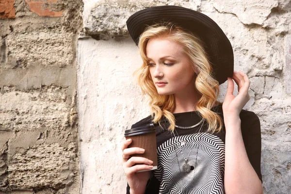 Belle fille avec une tasse de café dans la rue — Photo