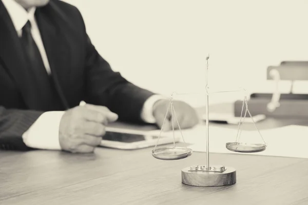 Handen van advocaat en schubben op de houten tafel. Retro stijl — Stockfoto