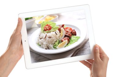 Tablet beyaz arka plan üzerinde tutan eller. Gıda tablet ekranında fotoğraf.