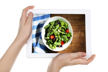 Tablet beyaz arka plan üzerinde tutan eller. Gıda tablet ekranında fotoğraf.
