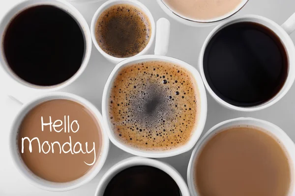 Text HELLO MONDAY and cups of aromatic coffee, closeup — Stock Photo, Image