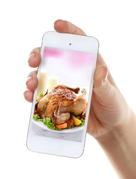 Female hand holding smartphone on white background. Photo of food on smartphone screen. — Stockfoto