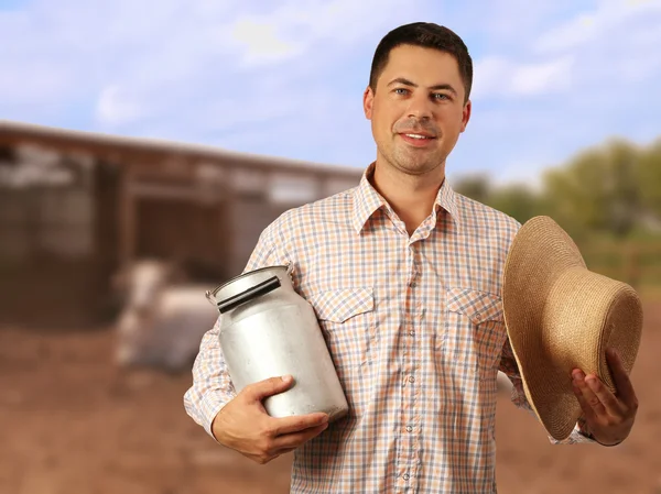 Milkman com regador pode no fundo desfocado fazenda de laticínios — Fotografia de Stock