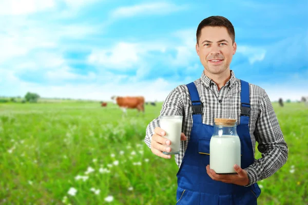 Milkman com copo e frasco sobre no fundo do prado desfocado — Fotografia de Stock
