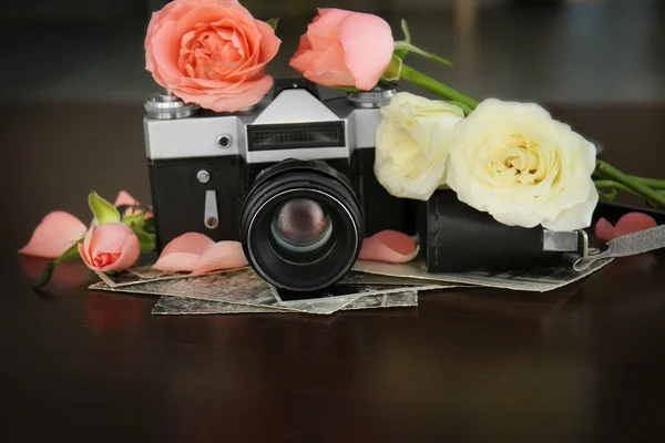 Cámara vintage y hermosas rosas en mesa de madera — Foto de Stock