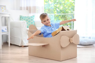 Küçük çocuk kapalı karton uçak ile oynamak