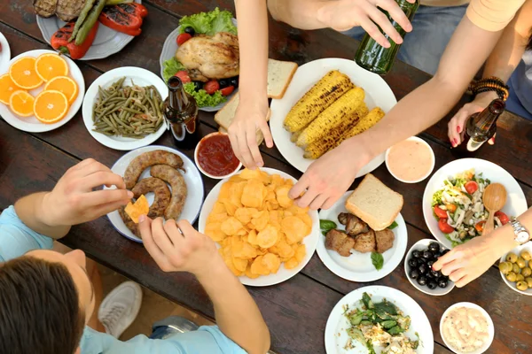 Amigos comendo em piquenique — Fotografia de Stock