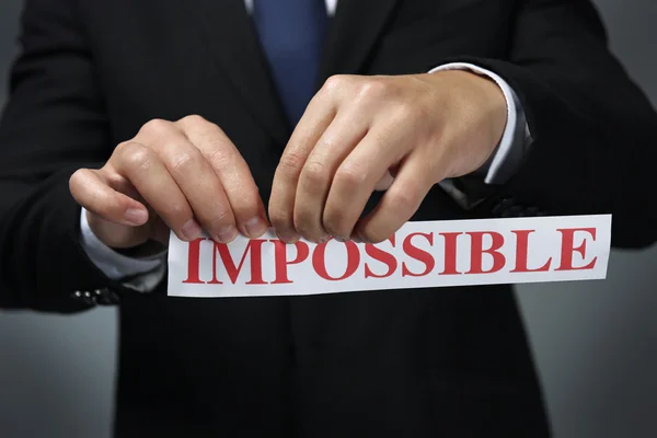 Empresario rasgando papel con palabra imposible — Foto de Stock