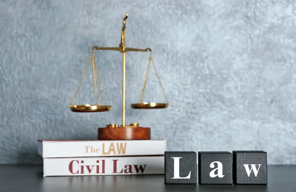 Wooden cubes with word LAW and scales on a table — Stock Photo, Image