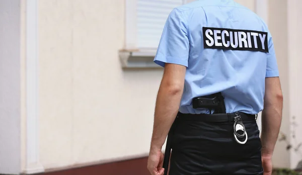 Male security guard standing back outdoors — Stockfoto