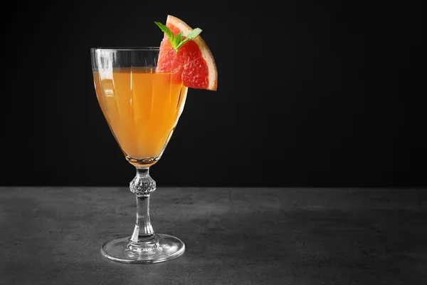 Delicious cocktail with grapefruit slice on gray table — Stock Photo, Image