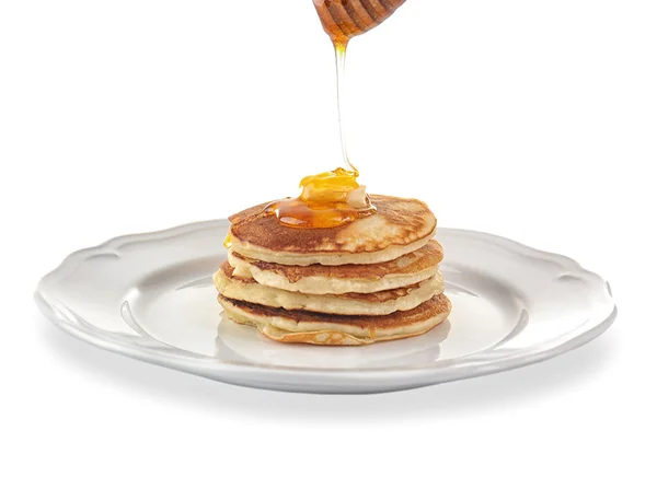 Panqueques sabrosos con miel y mantequilla en el plato, aislados en blanco —  Fotos de Stock