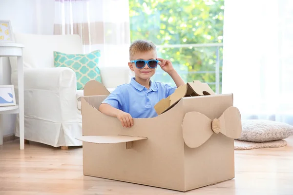 Little boy playing with cardboard airplane indoors — Stock Photo, Image