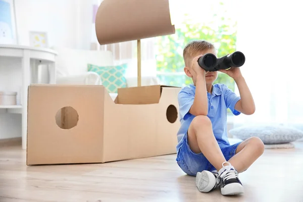 Kleine jongen spelen met kartonnen schip binnenshuis — Stockfoto