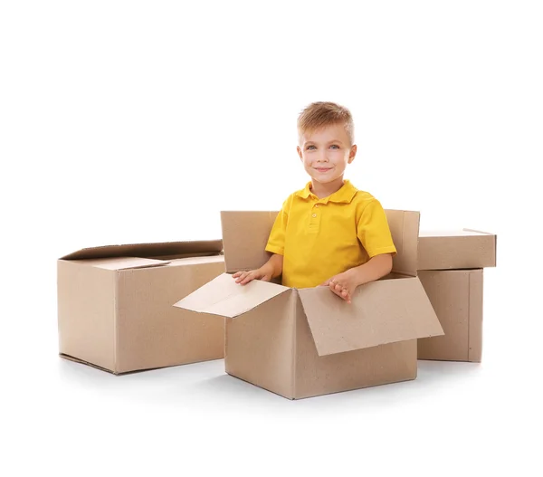 Мальчик играет с картонными коробками, изолированными на белом — стоковое фото