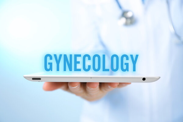 Gynecology concept. Professional doctor with tablet on blue background