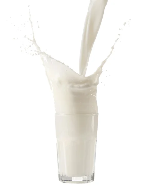 Milch in Glas auf weißem Hintergrund gießen — Stockfoto