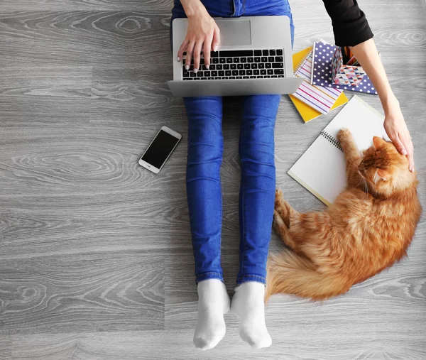 Nő Laptop gépelés és bolyhos macska padlón ül — Stock Fotó