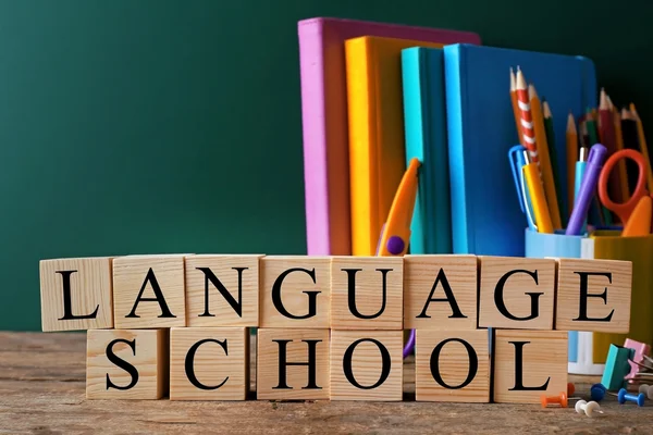 Papelería colorida y palabra LANGUAGE SCHOOL sobre la mesa — Foto de Stock