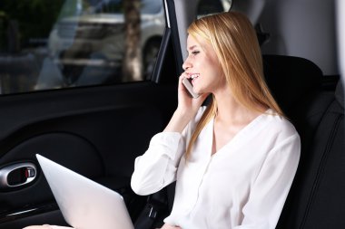 İş kadını ile laptop cep telefonu arabada tarafından konuşma
