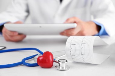 Kardiyogram, stetoskop ve doktor masada kırmızı kalp yakın görünümü