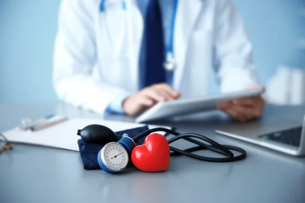 Cuore rosso e tonometro sul posto di lavoro medico — Foto Stock