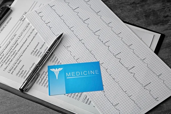 Conceito médico. Histórico médico, cartão de visita um gráfico de ECG em fundo cinza — Fotografia de Stock