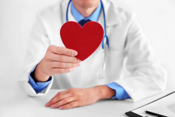 Male doctor holding red heart — Stock Photo, Image