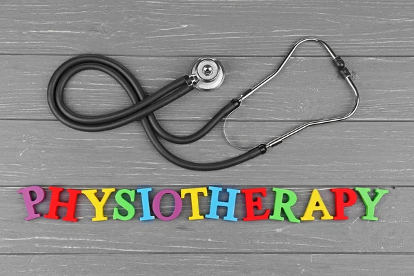 Concepto médico. Estetoscopio y palabra colorida Fisioterapia sobre fondo gris de madera — Foto de Stock