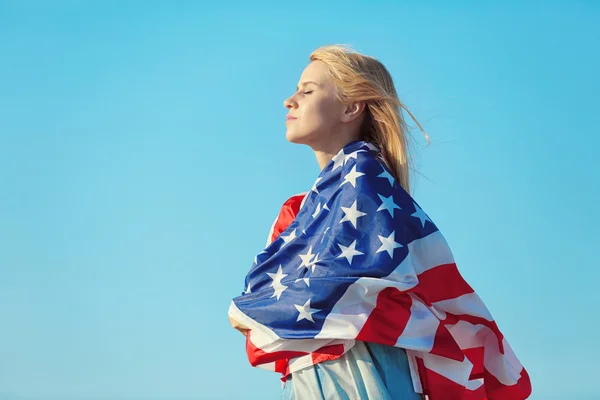 Joven mujer sosteniendo bandera americana —  Fotos de Stock