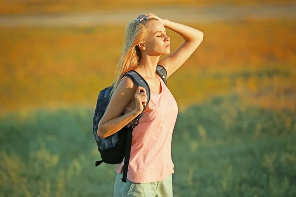 Młoda kobieta z plecaka na niewyraźne tło — Zdjęcie stockowe