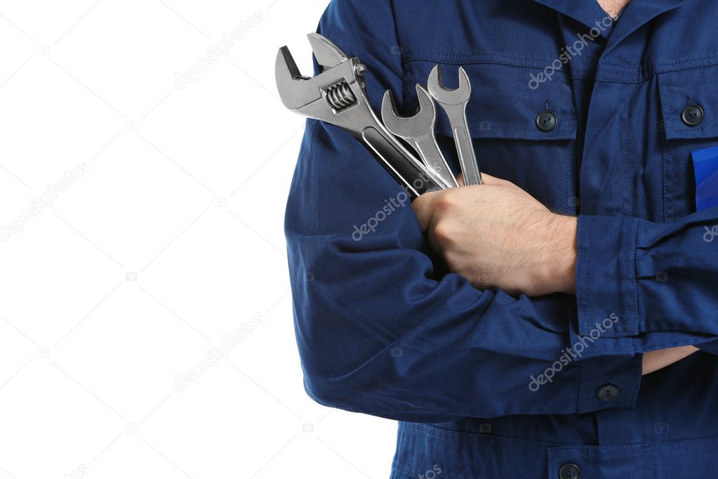 Mechanic in uniform with wrenches in crossed arms 