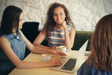 Kafede kahve içme dizüstü bilgisayar ile mutlu arkadaşlar