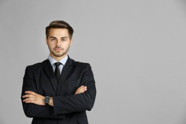 yakışıklı genç işadamı gri arka plan üzerinde