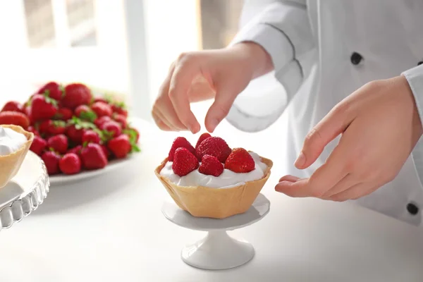 Chef hembra cocinando sabrosos pasteles con fresas — Foto de Stock