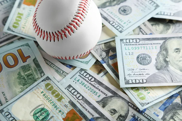 Balón de béisbol en billetes de dinero — Foto de Stock