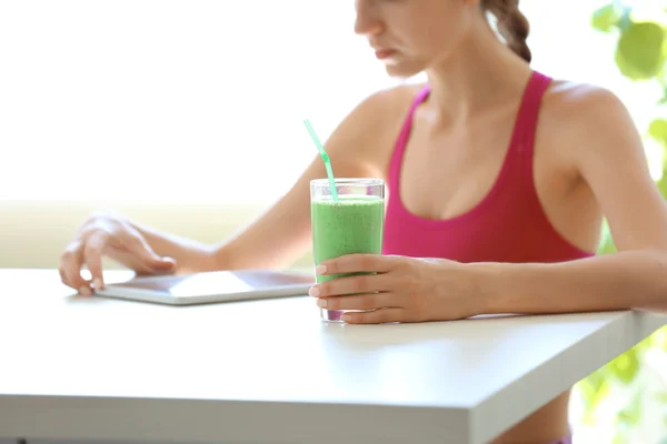 woman with tablet and smoothie