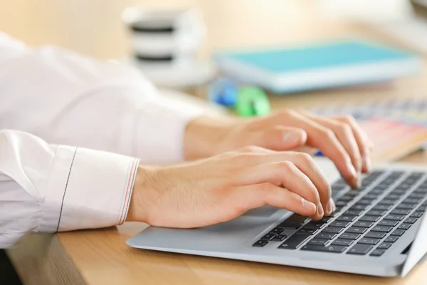 Uomo digitando sul computer portatile in ufficio, primo piano — Foto Stock