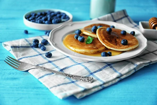 Tasty pancakes with blueberries, mint and honey on table — Stock Photo, Image