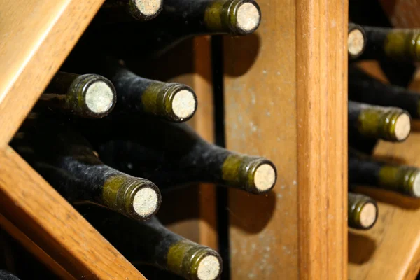 Бутылки с вином на деревянных полках в подвале — стоковое фото