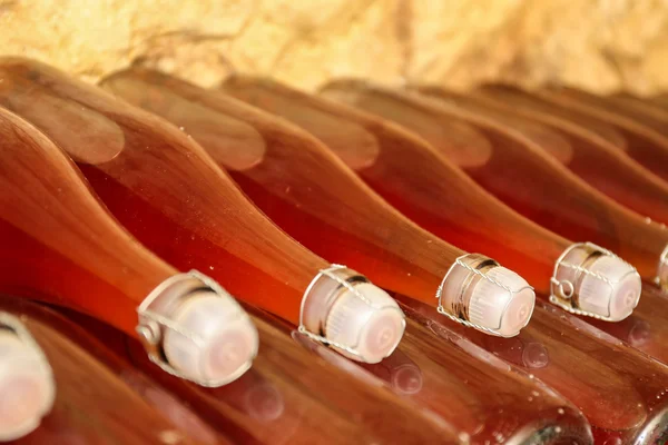 Bottles with wine in cellar, closeup — Stock Photo, Image