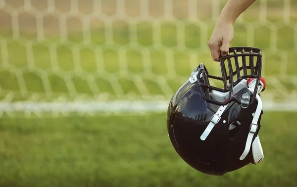 Mão segurando capacete de rugby — Fotografia de Stock