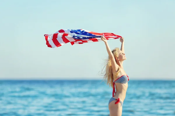 Młoda Kobieta Posiadający Amerykańską Flagę Wybrzeżu Tle Błękitnego Nieba — Zdjęcie stockowe