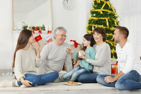 Ευτυχισμένη Οικογένεια Μπισκότα Και Γάλα Στο Σαλόνι Διακοσμημένο Για Χριστούγεννα — Φωτογραφία Αρχείου