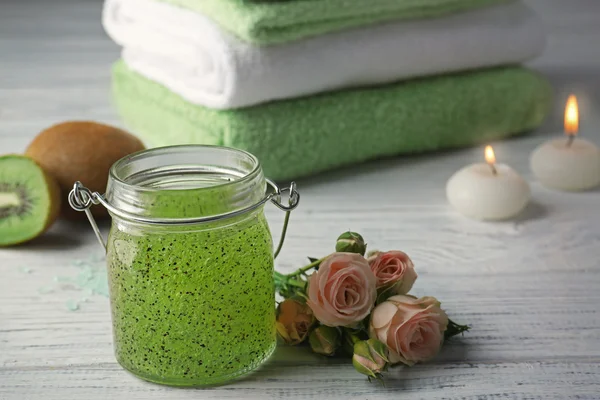 Body scrub and kiwi on wooden table — Stock Photo, Image