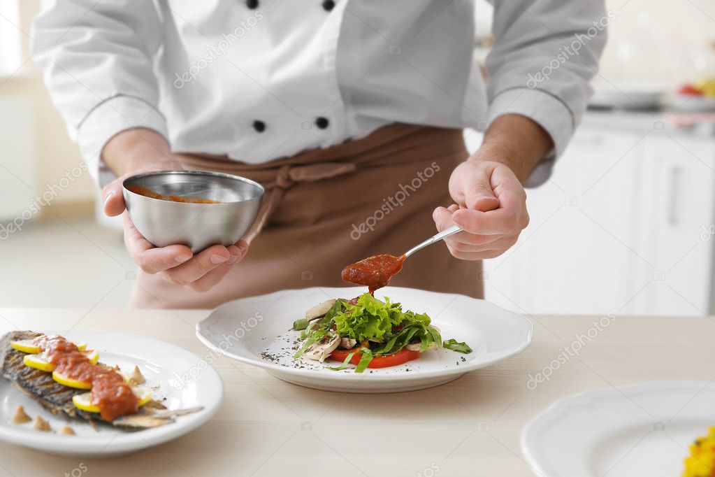 chef putting tomato sauce on dishes
