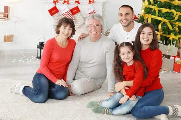 Ευτυχισμένη οικογένεια στο σαλόνι διακοσμημένη για τα Χριστούγεννα — Φωτογραφία Αρχείου