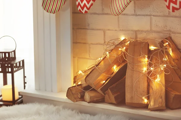 Fireplace with firewood and garland — Stock Photo, Image